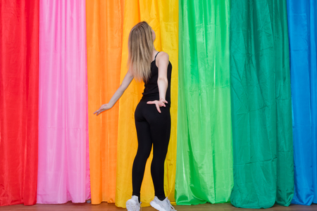 Flexible young woman in sportswear gracefully dancing on the background color of the canvasesの写真素材