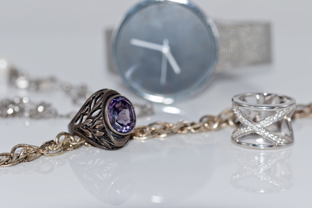 Silver ring and chain on the background of women's watchesの写真素材