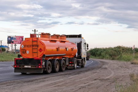 VOLGOGRAD - JULY 30: A truck hauling an orange fuel tanker on bypass road. July 22, 2016 in Volgograd, Russia.のeditorial素材