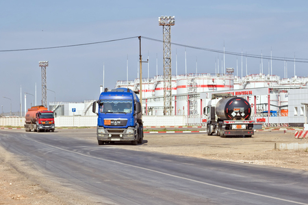 VOLGOGRAD - SEPTEMBER 16: Trucks with tanks for transportation of petroleum products and containers are on the road in front of refinery. September 16, 2017 in Volgograd, Russia.のeditorial素材