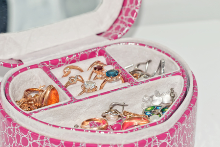 Various gold rings and earrings with precious stones and pearls on a velvet pad in the ladies ' boxの写真素材