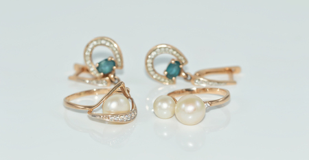 Elegant Golden ring with pearl on a reflective white surfaceの写真素材