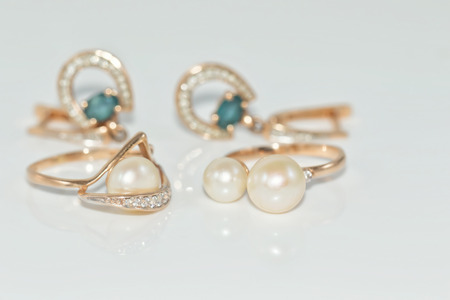 Elegant Golden ring with pearl on a reflective white surfaceの写真素材