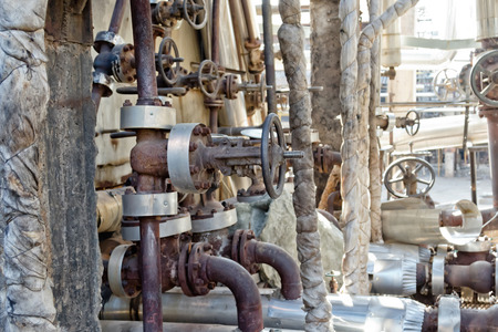 Old pipelines made of steel chromemolybdenum and valves on the service platform, in front of furnaces heating naphthaの写真素材