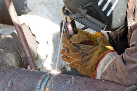 welder is repairing the defective area of the weld inside the parts of chemical apparatusの写真素材