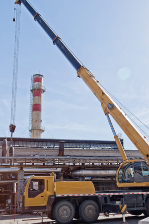 Automotive heavy lift crane is unfolded on the installation of a chemical factory in the time of repairの写真素材