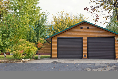 Small log cabin with 2 car garage built away from the city in a forestの写真素材