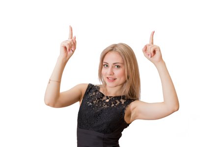 Smiling young woman with blond hair in jacket pointing finger up. Isolated portrait.の写真素材