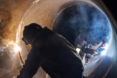 Welding works manual arc welding in the repair of the chemical apparatus by two welders at the same timeの写真素材