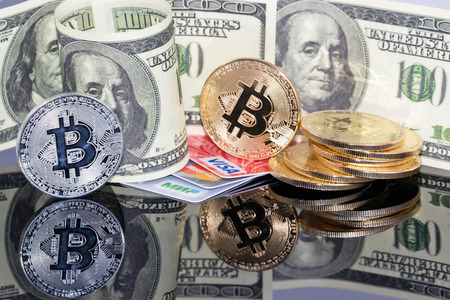VOLGOGRAD, RUSSIA - JANUARY 26: hundred-dollar bills, bitcoin coins and Bank plastic cards of different payment systems. January 26, 2018 in Volgograd, Russia.の写真素材