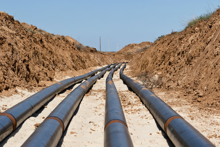 Laying pipelines in a special corrosion-resistant insulation in the trench on the sandの写真素材