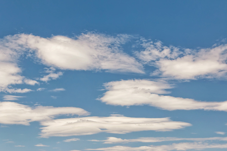 Unusual shape small fluffy clouds in the blue summer skyの写真素材