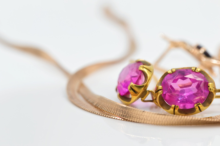 Gold earrings old style with large rubies lie next to the gold chainの写真素材