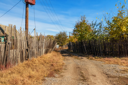 Sketches from the life of a small Russian village. Rickety old wooden fences, small wooden houses and power line polesの写真素材