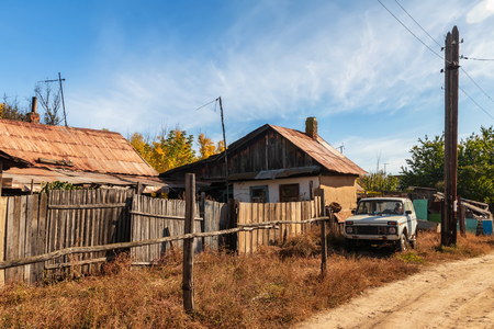 Sketches from the life of a small Russian village. Rickety old wooden fences, small wooden houses and power line polesの写真素材