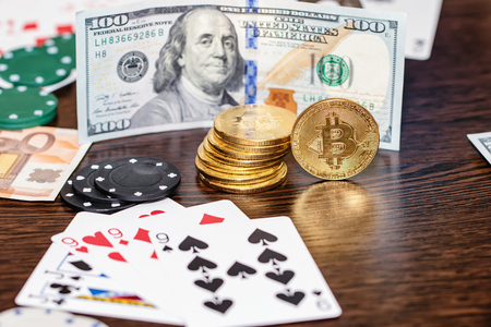 Attributes of gambling on a wooden table - money, cards, playing chips and bitcoinsの写真素材