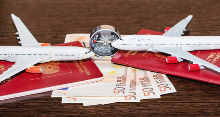 Passports, currency and toy airplanes are on the tableの写真素材