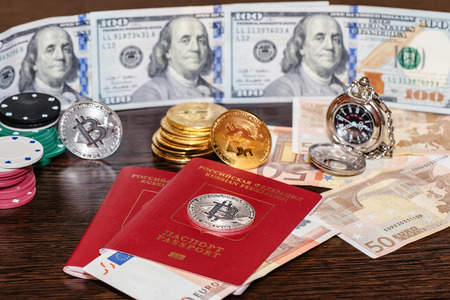 Pocket watches, dollars, euros and bitcoins lie on a wooden tableの写真素材