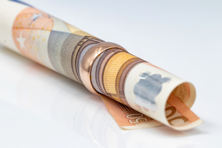 50 Euro bill rolled into a tube threaded into a gold ringの写真素材