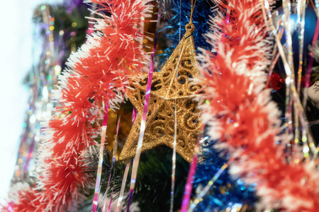 Christmas tree decorations hanging on the tree with colorful tinselの写真素材