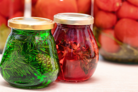 Jam of fir twigs and cones and mountain cranberries in small jars on the kitchen tableの写真素材