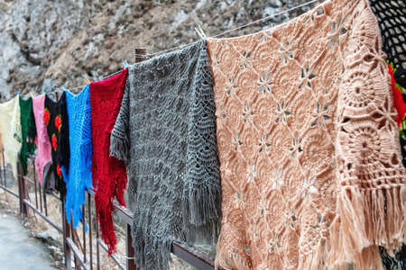 Downy shawls of different shapes and colors, which locals knit themselves for sale to tourists in the mountain gorgesの写真素材