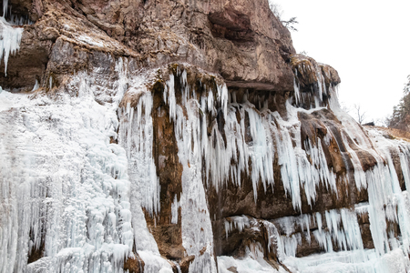 Large frozen icicles on the site of waterfalls in the mountainous area in winterの写真素材