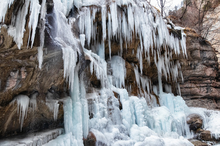 Large frozen icicles on the site of waterfalls in the mountainous area in winterの写真素材
