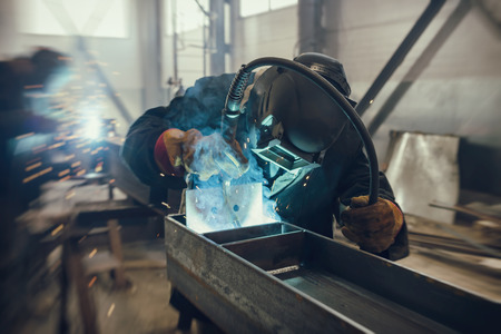 Welder performs welding work of metal structures in a complex spatial position semi-automatic weldingの写真素材