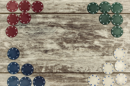 Casino chips on a light wooden background are laid out on the edges with the ability to make an inscription in the center. The concept of gambling and casinosの写真素材