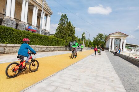 VOLGOGRAD - MAY 4: Parents with children ride bicycles on a new special path on the Central embankment. May 4, 2019 in Volgograd, Russia.のeditorial素材