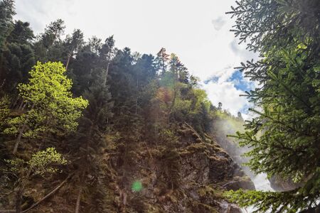 Stormy mountain river goes down into the valley immediately after the waterfallの写真素材