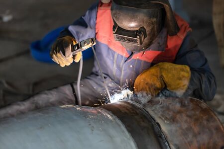 Manual arc welding of large diameter pipeline elements. Welding works are carried out in workshop...