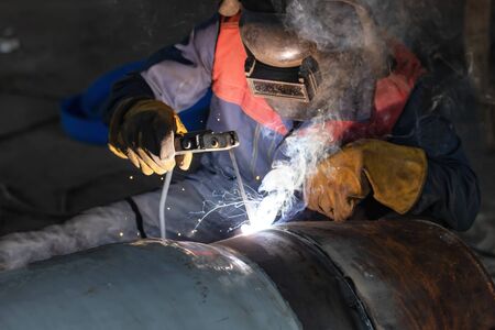 Manual arc welding of large diameter pipeline elements. Welding works are carried out in workshop conditionsの写真素材