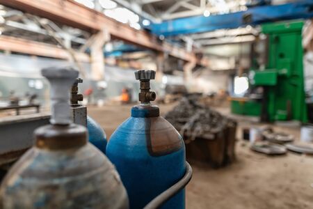 Gas cylinders for oxygen and argon are in a spacious , dark production shopの写真素材