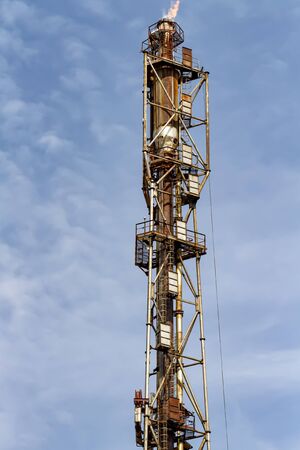 The old torch of the refinery after-burning the waste products of heavy gasesの写真素材