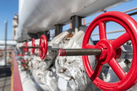 A number of new shut-off valves with red flywheels on the new hydrocracking plantの写真素材