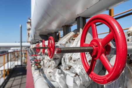 A number of new shut-off valves with red flywheels on the new hydrocracking plant
