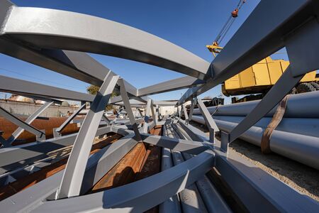 The section of metal structures ready for shipment lies on the production base under the open skyの写真素材