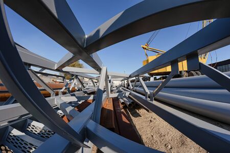 The section of metal structures ready for shipment lies on the production base under the open skyの写真素材