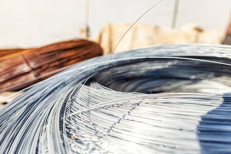 A large coil of stainless wire rests on a wooden palletの写真素材