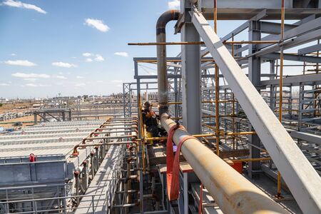 The welder performs the installation welding seam of the pipeline using scaffoldingの写真素材
