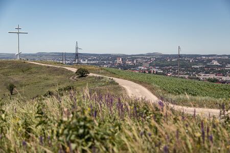 Dirt road leading to the Orthodox cross of worship, standing on the site of the Foundation of the villageの写真素材