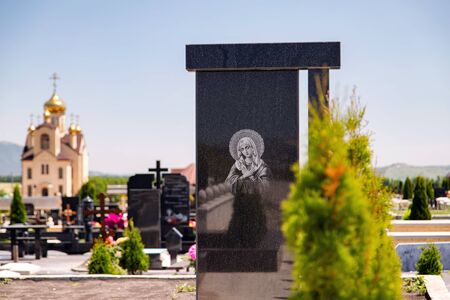 Black marble tombstone with an image of an Orthodox icon. Cemetery of the mountainous region of the Caucasusの写真素材