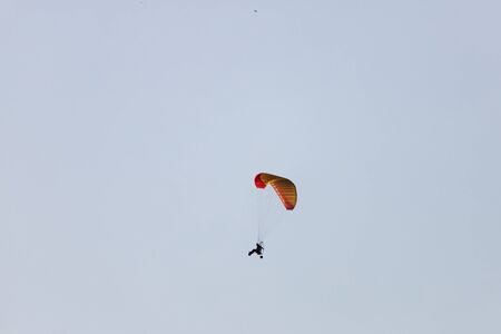 Tourists fly on motorcycle paragliders over the mountain rangeの写真素材