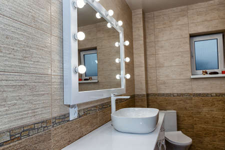 The interior of the bathroom with a big illuminated mirror, walk-in shower and elegant sinkの写真素材