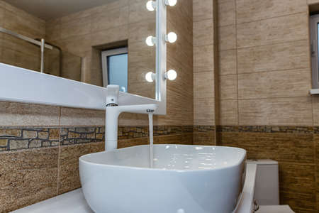 The interior of the bathroom with a big illuminated mirror, walk-in shower and elegant sinkの写真素材