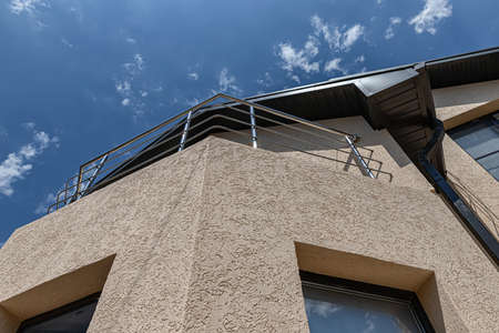 The walls of the cottage whose facade is plastered with decorative plaster "bark beetle". The view from the bottom upの写真素材