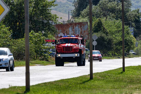 MINERALNYE VODY - SEPTEMBER 05: A large red fire truck on the Ural 4320 chassis is driving along the road to an emergency call. September 05, 2020 in Mineralnye Vody, Russia.のeditorial素材