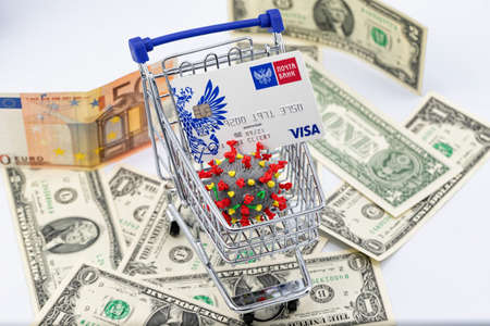 ESSENTUKI - SEPTEMBER 20: A model of coronavirus in a shopping cart and a VISA Bank card. September 20, 2020 in Essentuki, Russia.のeditorial素材